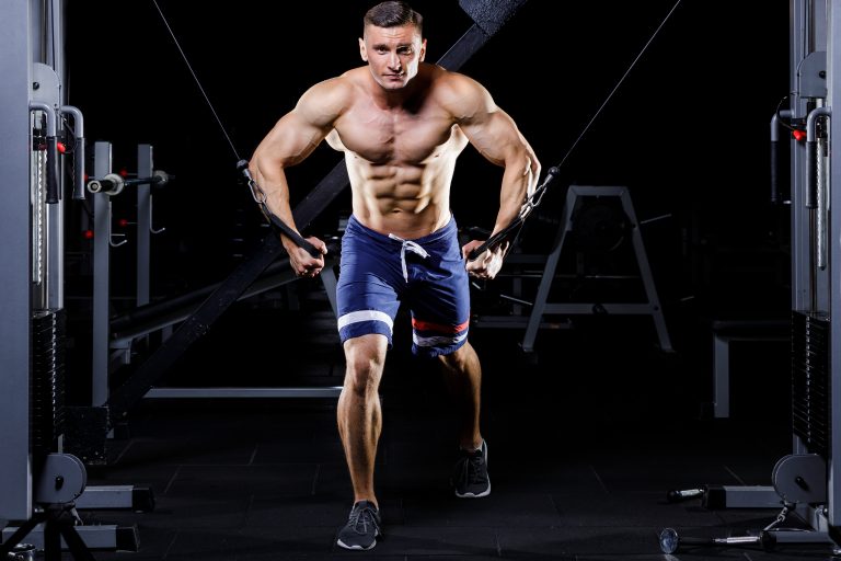 Male handsome bodybuilder gaining muscles in the gym